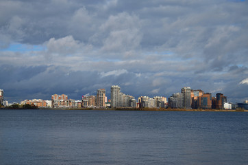 Fototapeta premium river and clouds on the horizon of the city's tall buildings