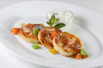 cheesecakes on a white plate with sweet sauce