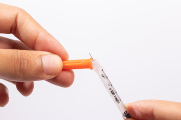 Hand holding an insulin syringe before being used