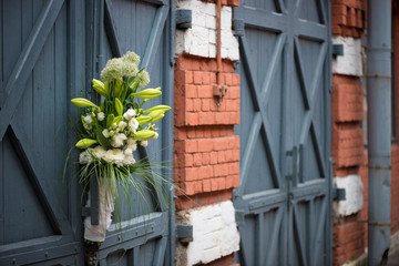 flowerarrangement with lilies and white lisianthus on a blue wooden door