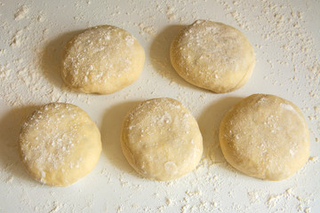 Fototapeta na wymiar Traditional russian patties made of raw dough with onion and rise filling prepared for baking