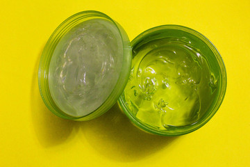 cosmetic gel, cream in a jar, on a yellow background, top view