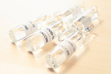 Ampoules with vaccine from KOVID-19, from coronavirus on a wooden light table. Close-up