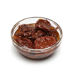 Sun dried tomatoes with olive oil in bowl on white background with shadow