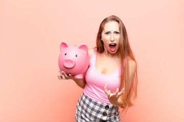 yound blonde woman looking angry, annoyed and frustrated screaming wtf or what‚Äôs wrong with...