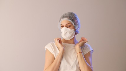 Attractive young woman in a protective medical mask. Coronavirus or COVID-19 prevention. 