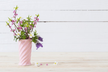 spring  flowers in vase on white wooden background