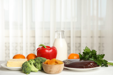 Fresh products rich in vitamin A on white wooden table