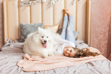Home portrait of cute child hugging with dog on the sofa