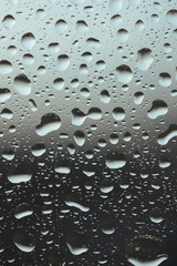 Macro pure rain drops on the glass against a cloud gray background