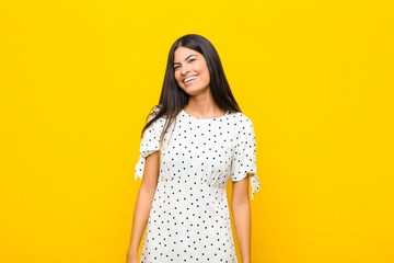 young pretty latin woman looking happy and friendly, smiling and winking an eye at you with a...