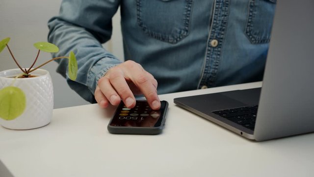 Male calculates expenses and finances sitting next to the laptop