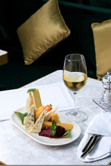 wine set. Assorted cheeses. brie, dor blue, frico, cheddar, picorino, ground pear with almonds. white wine.
