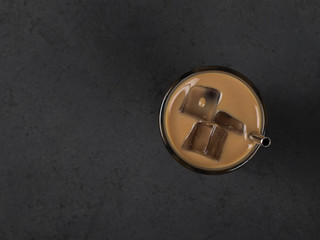  Iced coffee milk in a glass on a dark gray background top view