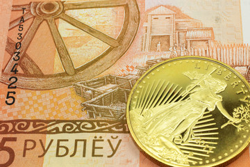 Fototapeta na wymiar A macro image of a orange five ruble note from Belarus with a gold coin. Shot close up.