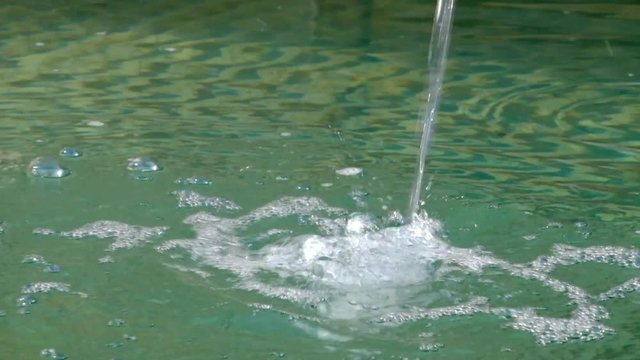 Wasser aus einer Quelle flie&szlig;t in einen Brunnen