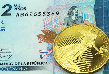 A macro image of a blue two thousand Colombian peso banknote with a gold coin.  Shot close up.