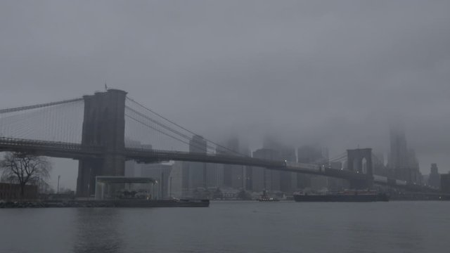 Brooklyn Bridge Manhattan skyline at dusk New York ungraded in HD long shot with tug boat
