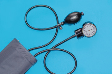 Aneroid blood pressure kit for pressure measurement on a blue background. medical concept, health care and the diagnosis of pneumonia in the coronavirus.