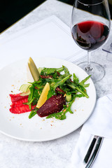 Arugula with salmon, brie cheese, ground pear and almonds and a glass of red wine. Place for text.