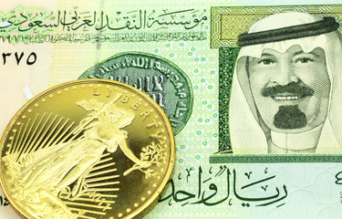 A macro image of a green one Saudi riyal bank note with a gold coin.  Shot close up.