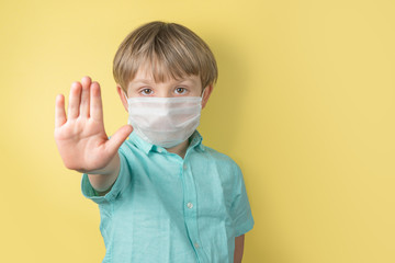 Coronavirus cocept, social distancing - boy wearing face mask pastel background