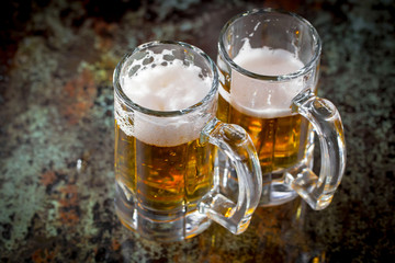 Light beer in a glass, on an old background.
