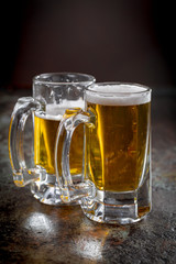 Light frothing beer in a glass, on an old background.