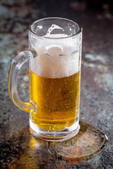 Light beer in a glass, on an old background.