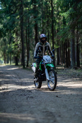 Obraz na płótnie Canvas off-road motorcycle trip in the forest, beautiful girl, feminism, sport, brutality, motorcyclist equipment, motorcycle driver, concept, active lifestyle, enduro