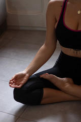 Close-up view of young beautiful woman doing morning yoga after waking up at home. Female model sitting cross-legged in Easy pose, Sukhasana posture and meditating.