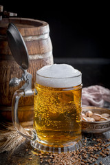 Light frothing beer in a glass, on an old background.