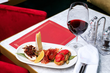 bruschetta with salmon hamon and sun-dried tomatoes and a glass of red wine. Place for text