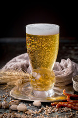 Light frothing beer in a glass, on an old background.