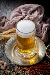 Light frothing beer in a glass, on an old background.