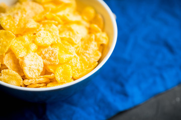 Tasty crispy corn flakes in bowl on the rustic background. Selective focus. Shallow depth of field.