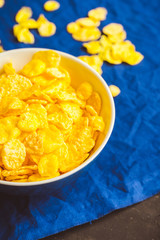 Tasty crispy corn flakes in bowl on the rustic background. Selective focus. Shallow depth of field.