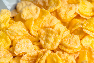 Tasty crispy corn flakes in bowl on the rustic background. Selective focus. Shallow depth of field.