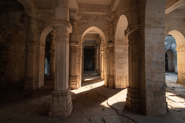 A wide angle shot of the arches and pillars inside the ruins of the Jama Masjid in the Uparkot Fort in Junagadh in Gujarat, India.