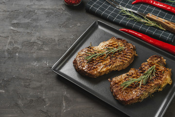 Grilled Beef steaks served with rosemary on  metal tray, close up