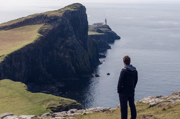 Man looking to the neist point lighthouse