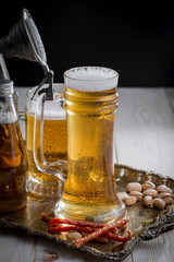 Light frothing beer in a glass, on an old background.