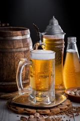 Light frothing beer in a glass, on an old background.