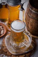 Light frothing beer in a glass, on an old background.