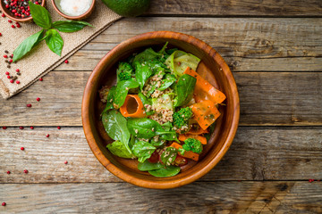 Salad with quinoa and shpinach on wooden table