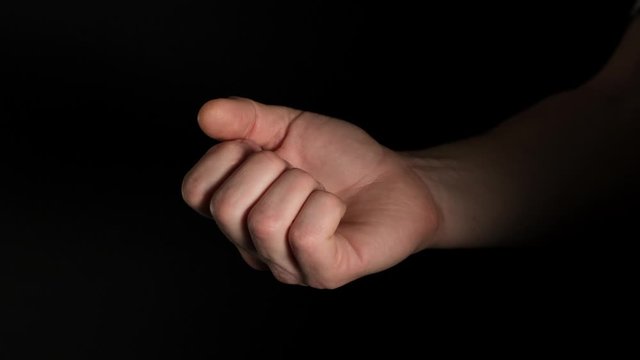 Human male palm clench a fist isolated on black background. Close up.