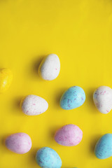 Fototapeta na wymiar Easter eggs colourful background yellow white blue pink. Flat lay. Minimal concept.