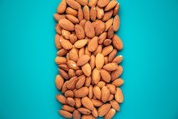 top view on a bunch of almonds on a turquoise background