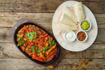 Fajitas with beef on wooden table
