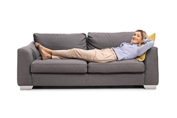 Happy woman resting on a sofa after work